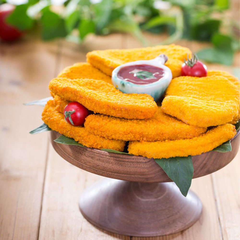 Breaded and golden forming chicken schnitzel, a hearty meal option